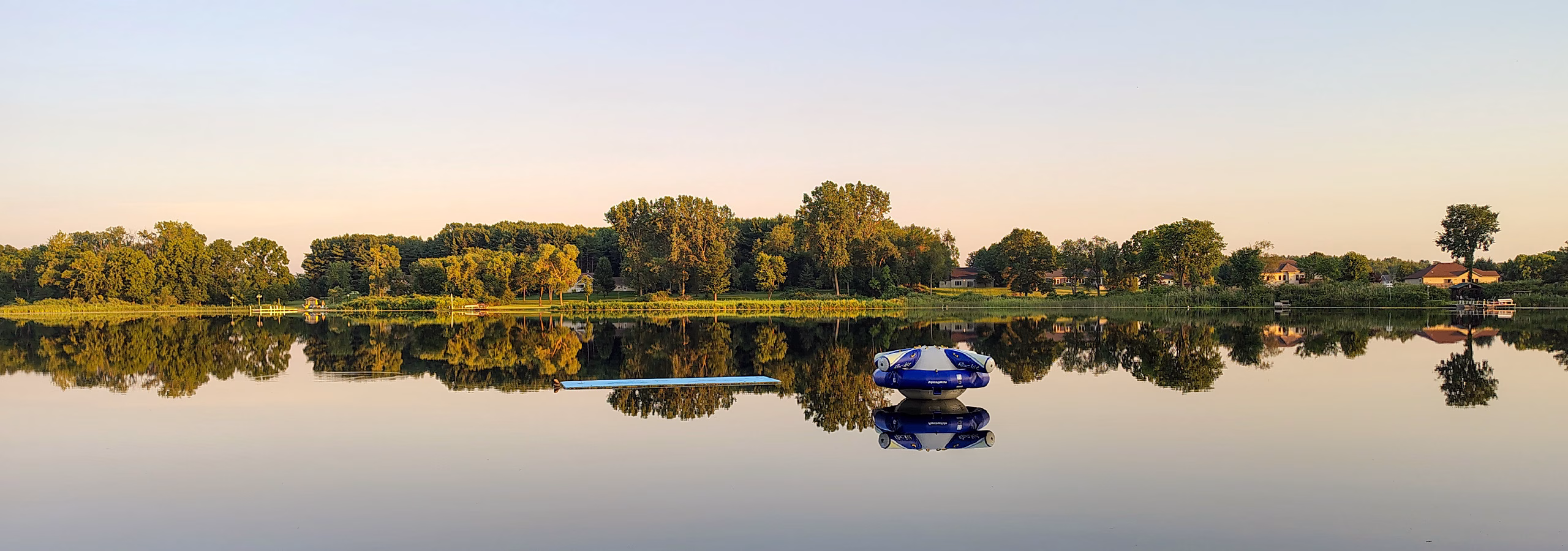 Trees in the distance reflected on a lake at Lutheran Outdoor Ministries: Indiana-Kentucky (LOMIK)